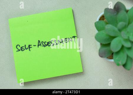 Concept of Self-assessment write on sticky notes isolated on Wooden Table. Stock Photo