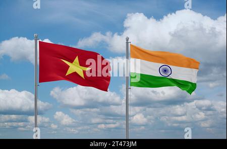 India and Vietnam flags waving together on blue cloudy sky, two country relationship concept Stock Photo