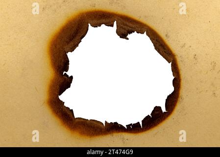 Burnt hole in yellow paper. Burnt paper Stock Photo