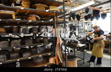 PRODUCTION - 24 October 2023, Thuringia, Altenburg: At Hut und Kostüm GmbH, milliner Thomas Krause works on silk cylinders in his workshop. The staff and employees are currently working on various headgear, such as historical chakos, bowler hats, top hats and hats for the upcoming carnival season. They are among the special productions currently in high demand for carnival associations, for uniforms for the Elferrat and clothing for dance marionettes. The small Altenburg company with ten employees is one of the few companies in Germany that still manufactures top hats and bowler hats, among ot Stock Photo