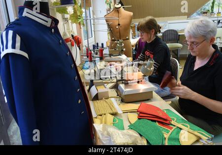 PRODUCTION - 24 October 2023, Thuringia, Altenburg: At Hut und Kostüm GmbH, ladies' tailors Cornelia Windisch (r) and Solveig Nolte sew parts for caps that are part of a uniform. The employees are currently working on various headwear items, such as historical chakos, bowler hats, top hats and hats for the upcoming carnival season. They are among the special productions currently in high demand for carnival associations, for uniforms for the Elferrat and clothing for dance marionettes. The small Altenburg company with ten employees is one of the few companies in Germany that still manufactures Stock Photo