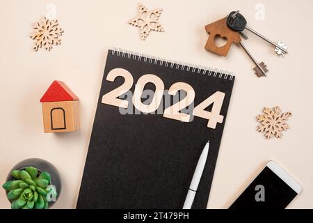 New Year Aims 2024. To Do List. Empty Notebook at the Desk with Decorative House Model. Top view. Creating Plan, Resolution. New Life, Start Up, Begin Stock Photo