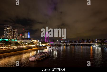 London, UK: London cityscape and River Thames at night. Showing London Eye, Royal Festival Hall and Golden Jubilee Bridge. Seen from Waterloo Bridge. Stock Photo