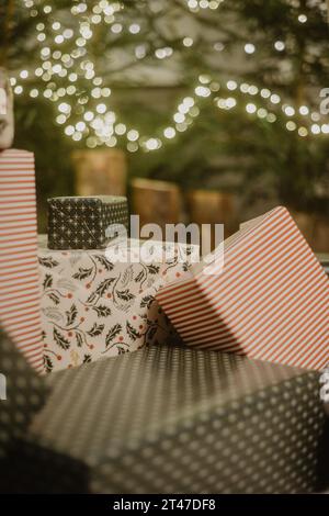 Beautiful Christmas gift boxes on floor near fir tree in room Stock Photo