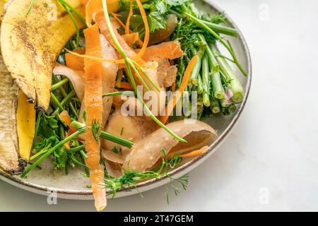 Recycle kitchen waste, Composting pile of rotting kitchen leftover fruits and vegetable scraps on plate on white background or surface with copy space Stock Photo