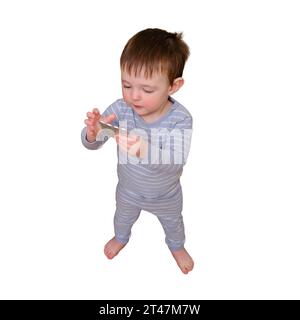 Toddler baby opened the cabinet drawer with pills and medicine, isolated on white background. Child boy holding a pack of pills in the home living roo Stock Photo