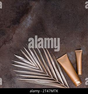 Golden palm leaf and golden bottles on the marble background. High quality photo. Stock Photo