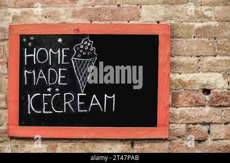 hand drawn home made icecream sign board hanged on a wall Stock Photo