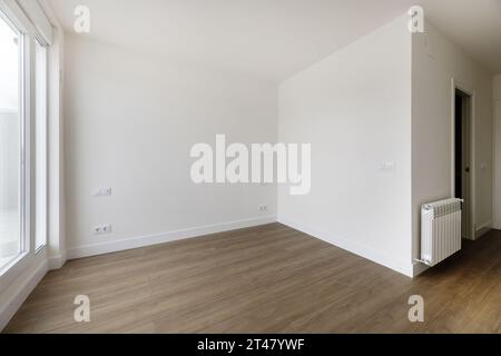 Empty room in a house with off-white painted walls, wooden floors Stock Photo