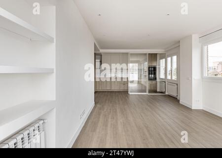 Empty room in a house with white painted walls, wooden floors, white aluminum radiators Stock Photo
