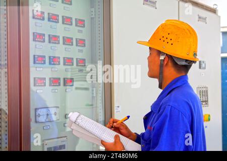 TANGSHAN - JUNE 18: Technical personnel in the control room meter reading record, in a iron and steel co., on June 18, 2014, Tangshan city, Hebei Prov Stock Photo