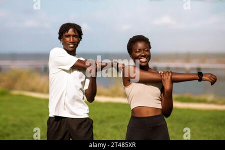 Healthy Lifestyle Concept. Happy black millennial couple training together outdoors Stock Photo