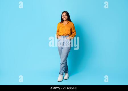 Indian lady standing full length with hands in pockets, studio Stock Photo