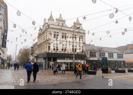 People walk under Christmas decorations in the town centre of Middlesbrough, UK at the junction of Linthorpe Road and Corporation Road Stock Photo
