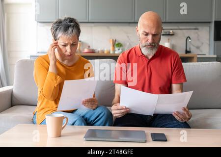 Financial Crisis. Stressed Senior Couple Checking Documents At Home Stock Photo