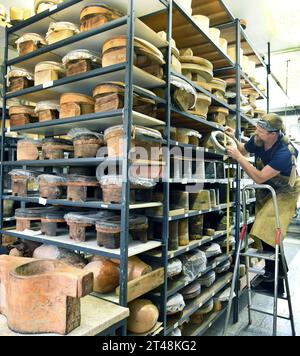 24 October 2023, Thuringia, Altenburg: At Hut und Kostüm GmbH, milliner Thomas Krause searches for a head size for a hat on shelves filled with hundreds of wooden heads, some of them historic, in his workshop. The employees are currently working on various headwear items, such as historical chakos, bowler hats, top hats and hats for the upcoming carnival season. They are among the special productions currently in high demand for carnival associations, for uniforms for the Elferrat and clothing for dance marionettes. The small Altenburg company with ten employees is one of the few companies in Stock Photo