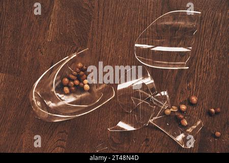 Top view of a transparent mug broken in close-up from under compote with raisins. Pieces of broken glass lie on the floor with space to copy. High quality photo Stock Photo