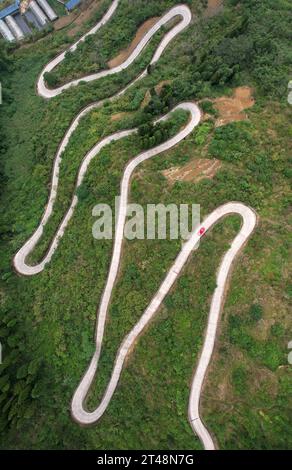 Neijiang, China. 29th Oct, 2023. NEIJIANG, CHINA - OCTOBER 28, 2023 - An aerial photo shows a car driving along a winding country road in Xinquan village, Neijiang City, Sichuan Province, China, October 28, 2023. (Photo by Costfoto/NurPhoto) Credit: NurPhoto SRL/Alamy Live News Stock Photo