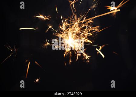 Burning sparkler light on black background. New year party background. Overlay of  New Year sparkles. Stock Photo