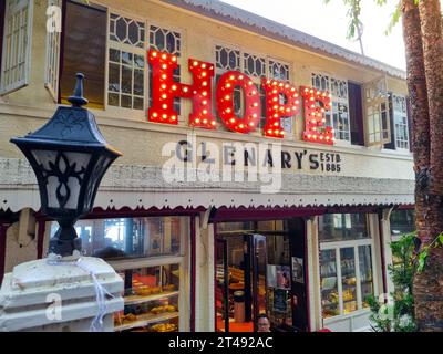 Panning shot showing the signboard of Glenary's Hope showing the famous landmark cafe bakery that is a must visit for tourists on mall road in Stock Photo