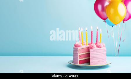 Pink birthday cake with birthday candles and pink and yellow party balloons against a blue background Stock Photo