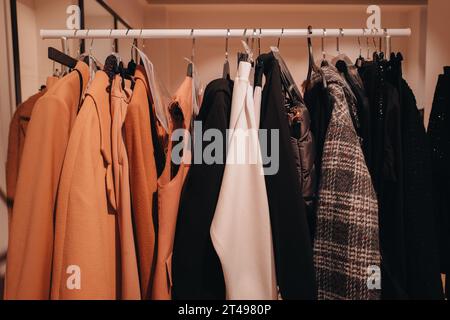 Row of different female clothes hanging on rack in hipster fashion show  room in shopping mall. Trendy women wear Stock Photo - Alamy