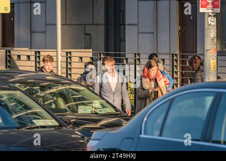 Young people, lit by the Sun, going to work at the morning rush hour in Dublin. Ireland Stock Photo