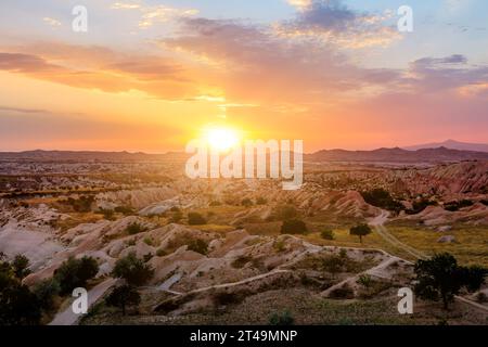 Cappadocia sunset with vibrant colors, captures the final beams of sunlight, casting luminous glow upon the extraordinary scenery beneath of Kayasehir Stock Photo