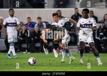 LAFC midfielder Mateusz Bogusz (19) is fouled by Vancouver Whitecaps midfielder Andrés Cubas (20) during game 1 of the first round of MLS playoffs, Sa Stock Photo