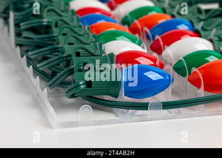 New Christmas string lights in packaging isolated on white background. Holiday decoration safety and lighting concept. Stock Photo