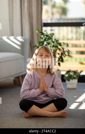 Funny meditating girl sitting on the floor Stock Photo - Alamy