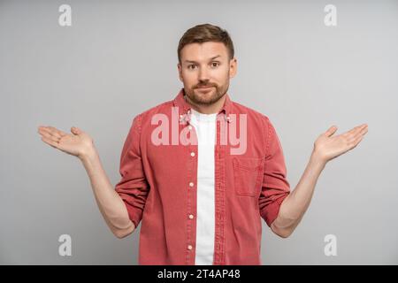 Confused middle aged man feeling embarrassed about ambiguous question, having doubts, no idea. Stock Photo