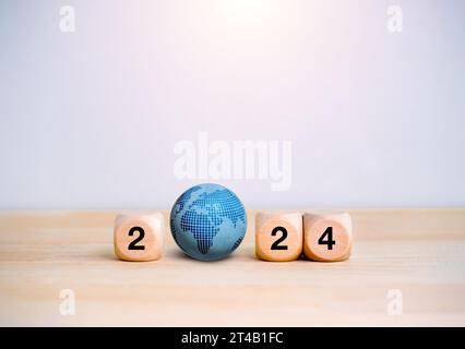 2024 Happy new year with business technology and digital global network concepts. 2024 number on wood cube blocks with blue earth sphere isolated on w Stock Photo