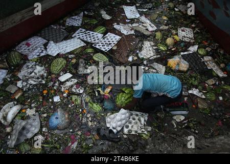 Dhaka Bangladesh march24 2023, A boy collected discar desd watermelon in the dirty water of buriganga river at sadarghat launch Terminal dhaka . Nazmul islam/alamy live news. Stock Photo
