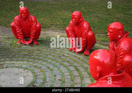 Sculpture Meeting by Wang Shugang 2013, sculpture group, red, figures, circle, sitting, men, Chinese, Chinese monks, kneeling, heads, back Stock Photo