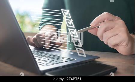 Document management concept. Businessman using laptop computer and touching to online electronic paper for approve. Electronic smart checklist and doc Stock Photo