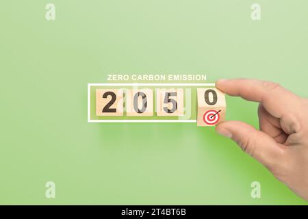 Net zero by 2050. hand holding wooden cube with target. Low carbon,carbon neutral concept. Net zero greenhouse gas emissions target. Climate neutral l Stock Photo