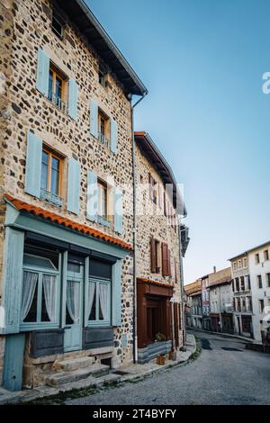 Streets of the medieval village of Allegre, with beautiful stonehouse, some with cute blue shutters in the center of France (Haute Loire) Stock Photo