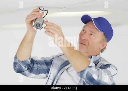 mature technician is replacing cctv cameras Stock Photo