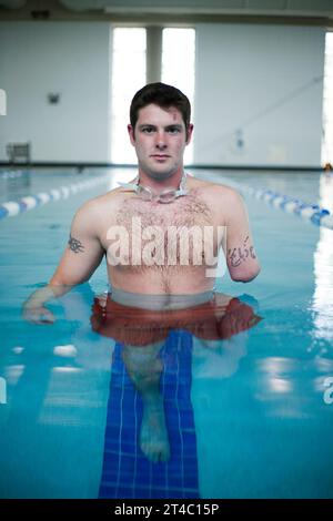 An Iraq War vetern begins rehab in a swimming pool after losing his left arm and left leg. Stock Photo