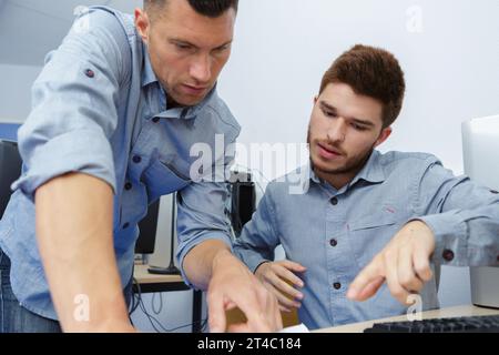 student and teacher discussing their work in college Stock Photo