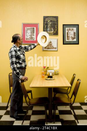 A portrait of a Latinoamerican man and his cowboy hat in a restaurant. Stock Photo