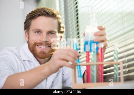 happy man checking liquids in the lab Stock Photo
