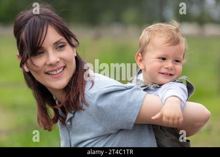 mother and her baby son on her back Stock Photo