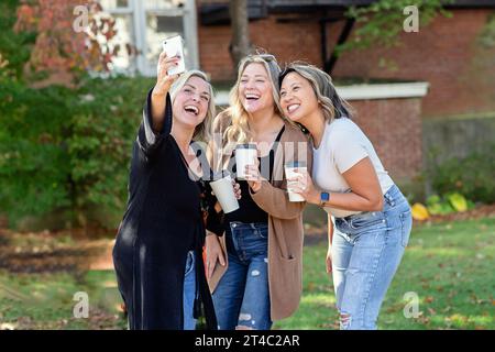 Three women laughing and taking a selfie Stock Photo