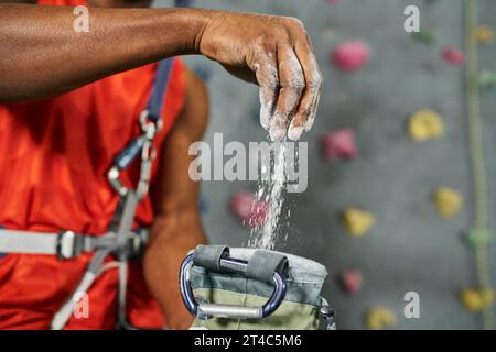 cropped view of hand of young african american man using talc powder on his equipment, bouldering Stock Photo