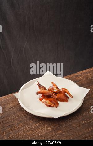Traditional Cantonese grilled pigeon on a white porcelain plate，Crispy Pigeon Stock Photo