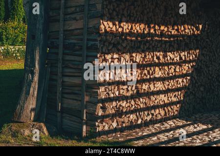 Stacked chopped firewood in farm shed for winter season, selective focus Stock Photo