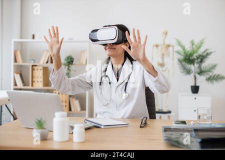 Lady doctor in lab coat wearing virtual reality glasses Stock Photo