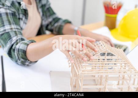 Architects working on a house model in a creative office. Stock Photo